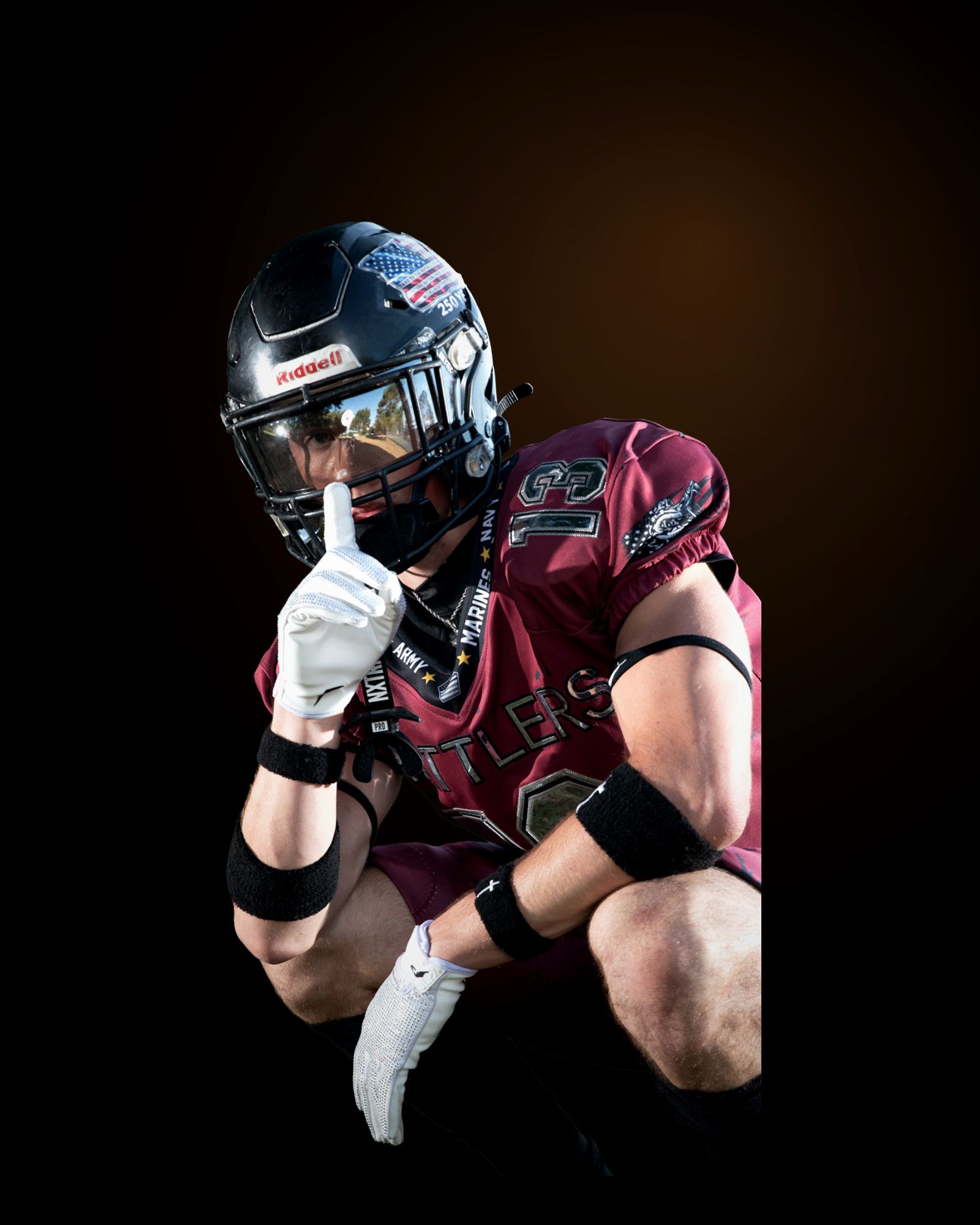 Jack Shepherd crouched low with one knee down, forearms braced on his thigh, rim light along his shoulders.