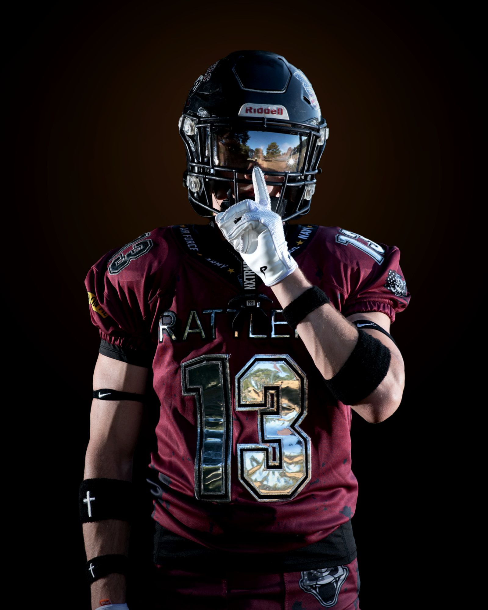 Jack Shepherd square to camera, forearms crossed low, one finger raised beside his visor, the number thirteen across his chest.
